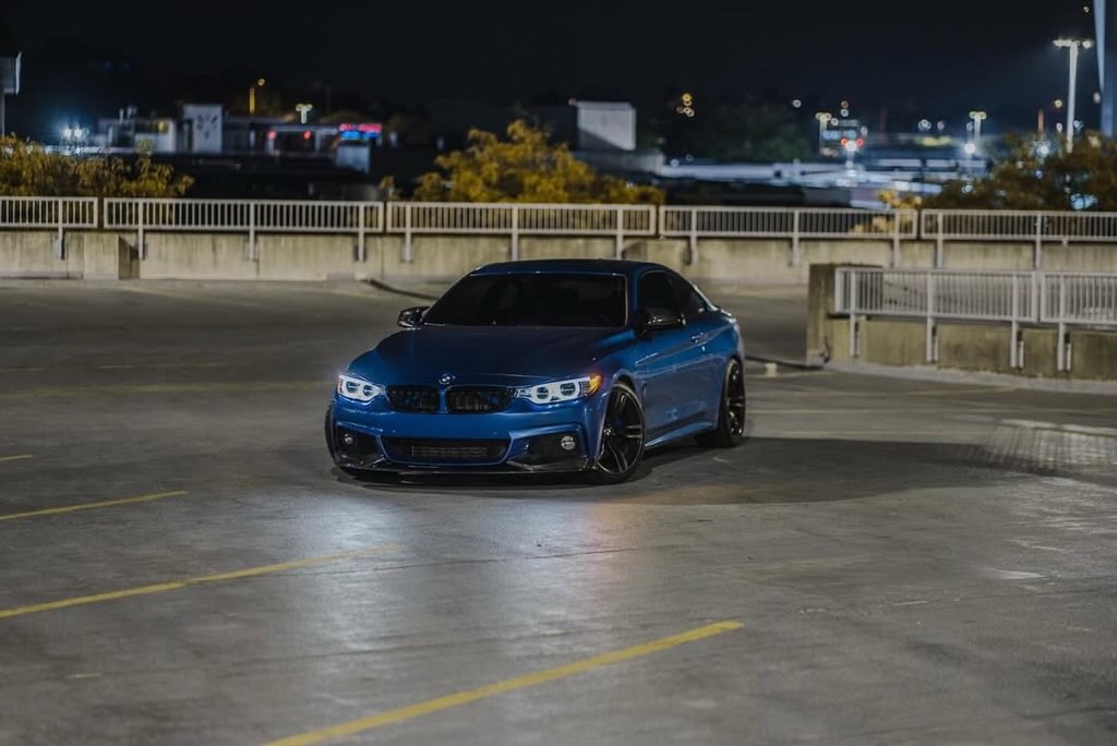 Blue car parked in a parking lot at night with MP Style Front Lip