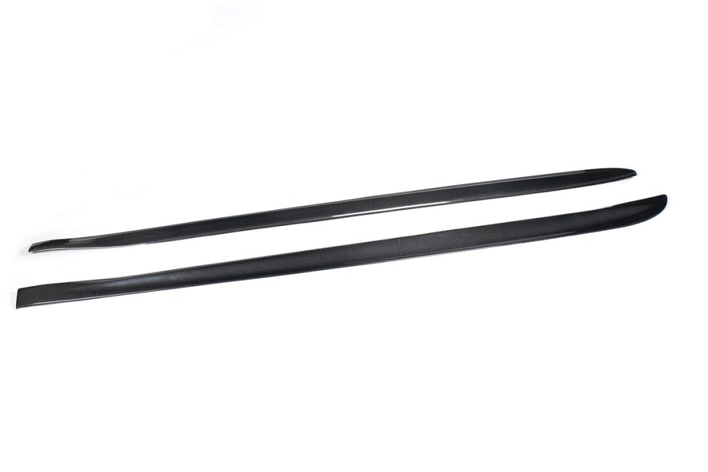 A pair of carbon fiber side skirts designed for the BMW F32, presented on a white background.