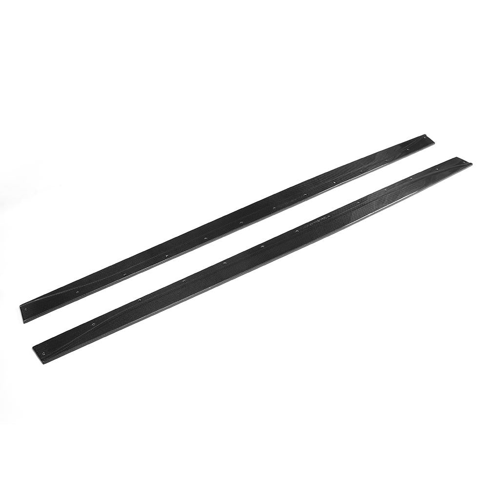 A pair of carbon fiber side skirts designed for a BMW vehicle, presenting a high-gloss black finish.