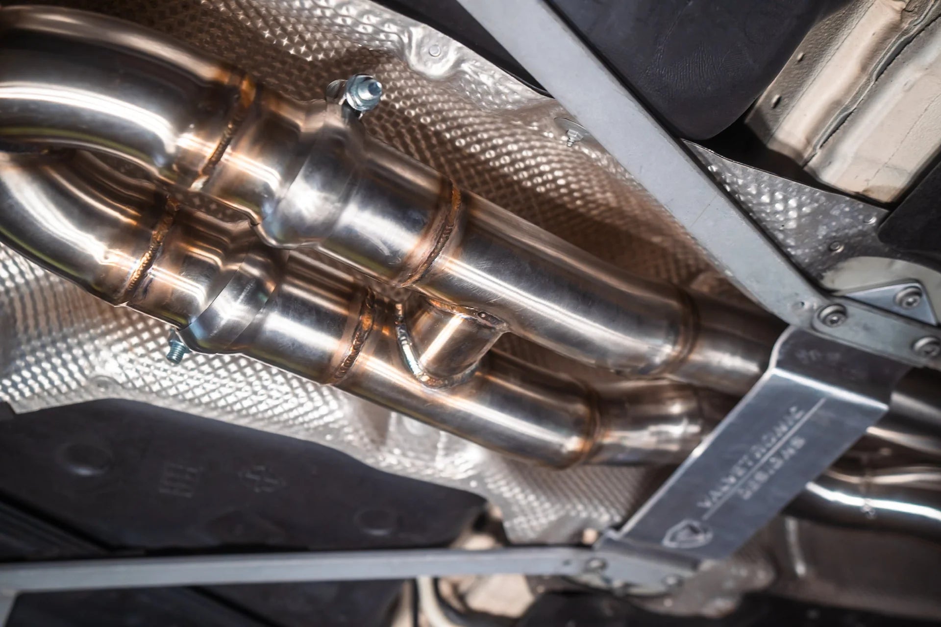 Angled view on the label for the Valvetronic BMW F8x M3 / M4 Equal Length Valved Sport Exhaust System | Insignist Motorsports Undercarriage 