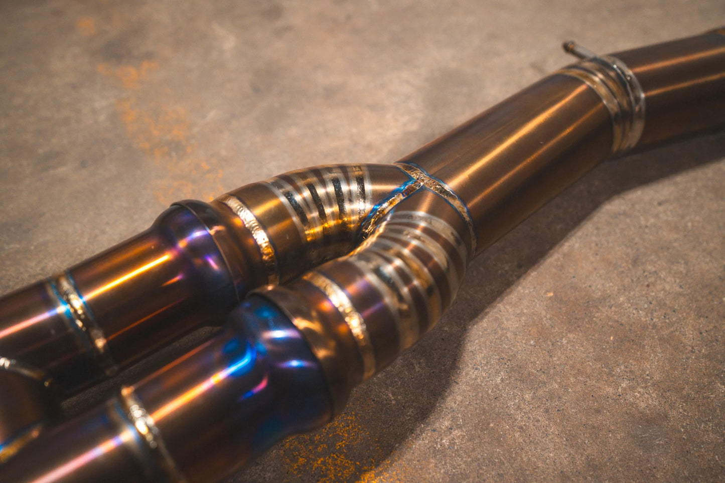 Angled view on titanium pipes for the Valvetronic BMW F8x M3 / M4 Equal Length Valved Sport Exhaust System | Insignist Motorsports